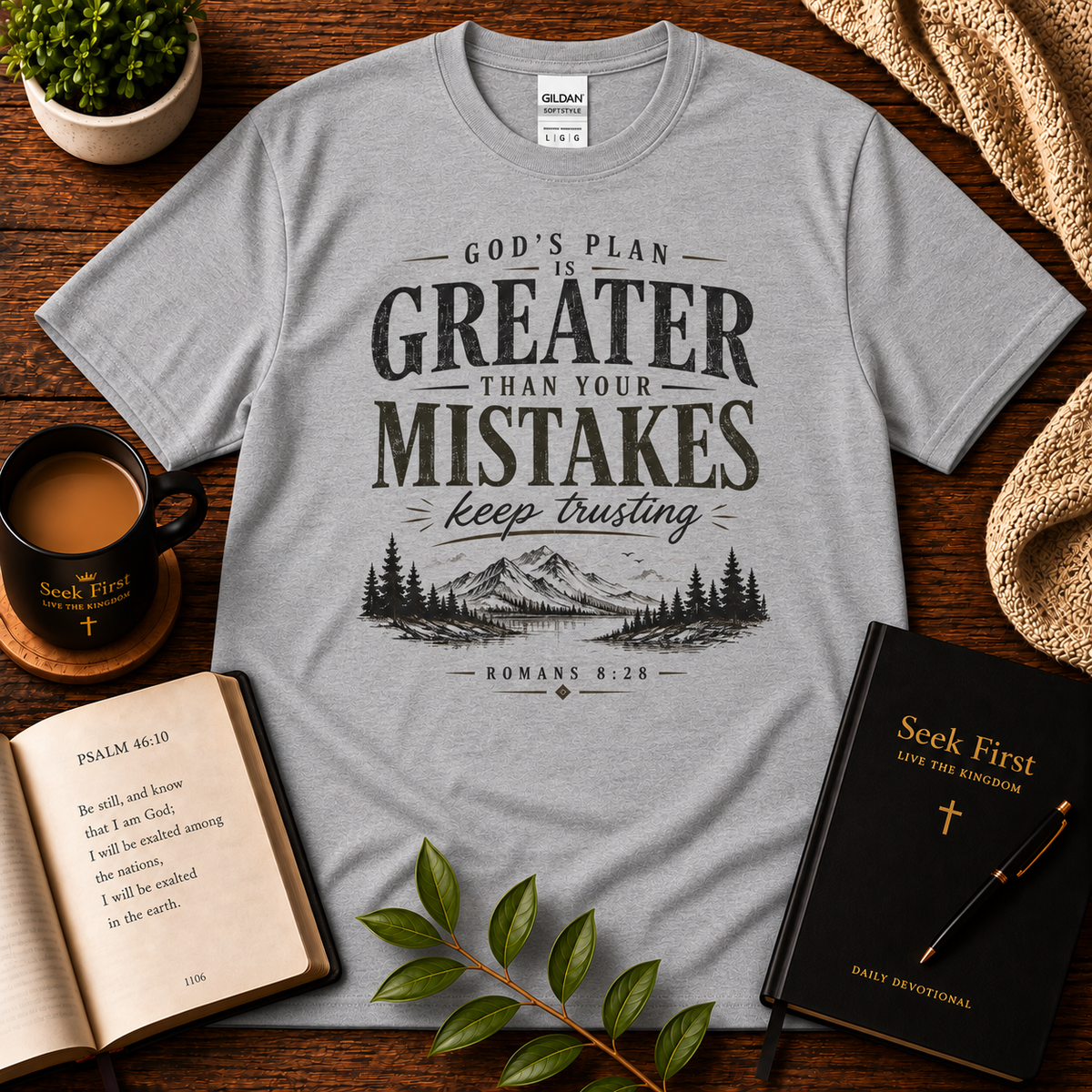Sport Grey God’s Plan Is Greater Than Your Mistakes Christian T-Shirt displayed with Bible, devotional, mug, and greenery