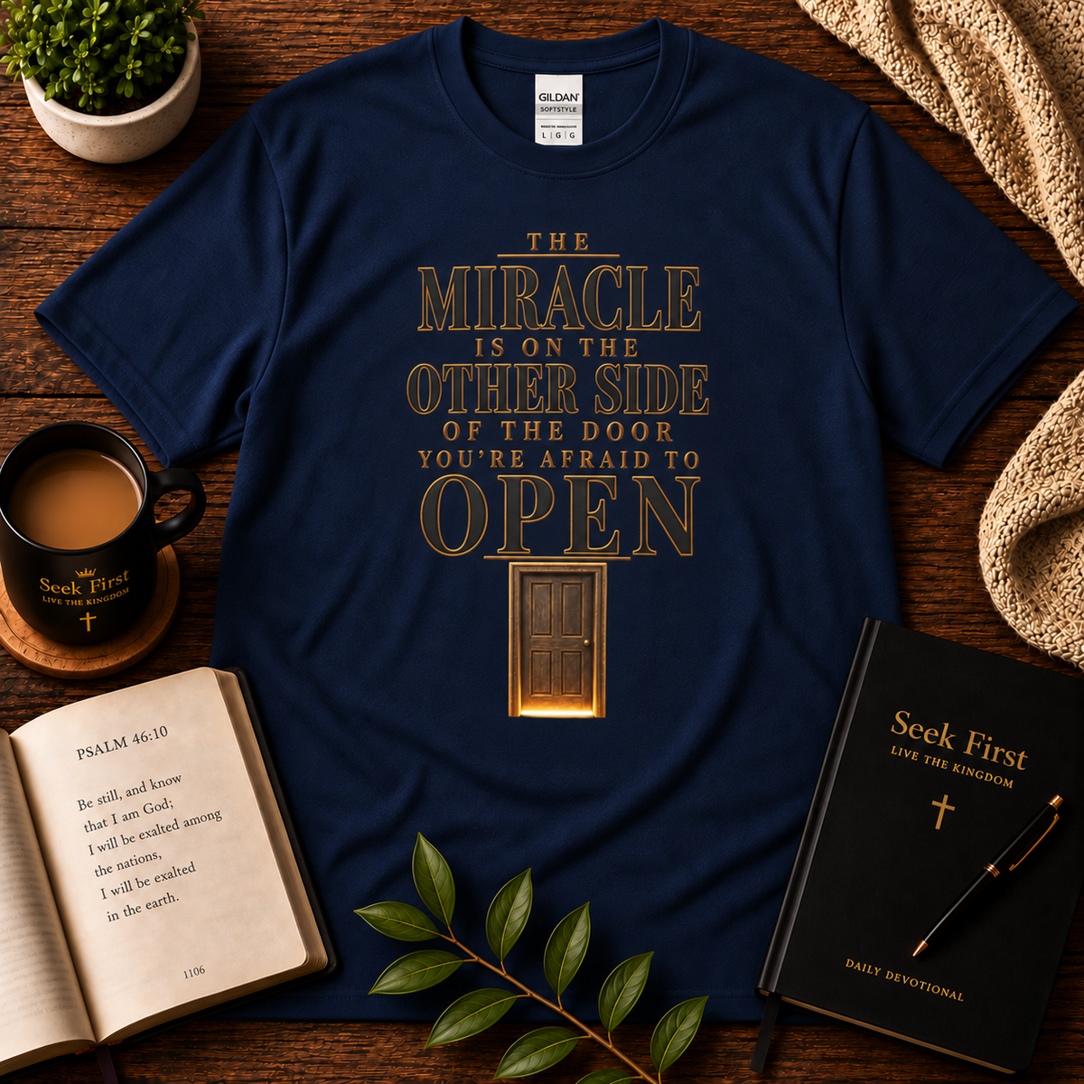 Navy The Miracle Is on the Other Side Christian Faith Tee displayed with Bible, devotional, mug, and greenery